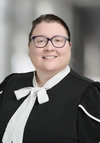 Celia McManus  smiling at the camera with glasses and a black and white blouse.