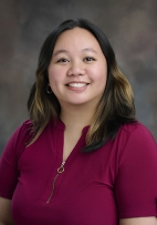 Agape Montero portrait smiling  wearing a burgundy. blouse 