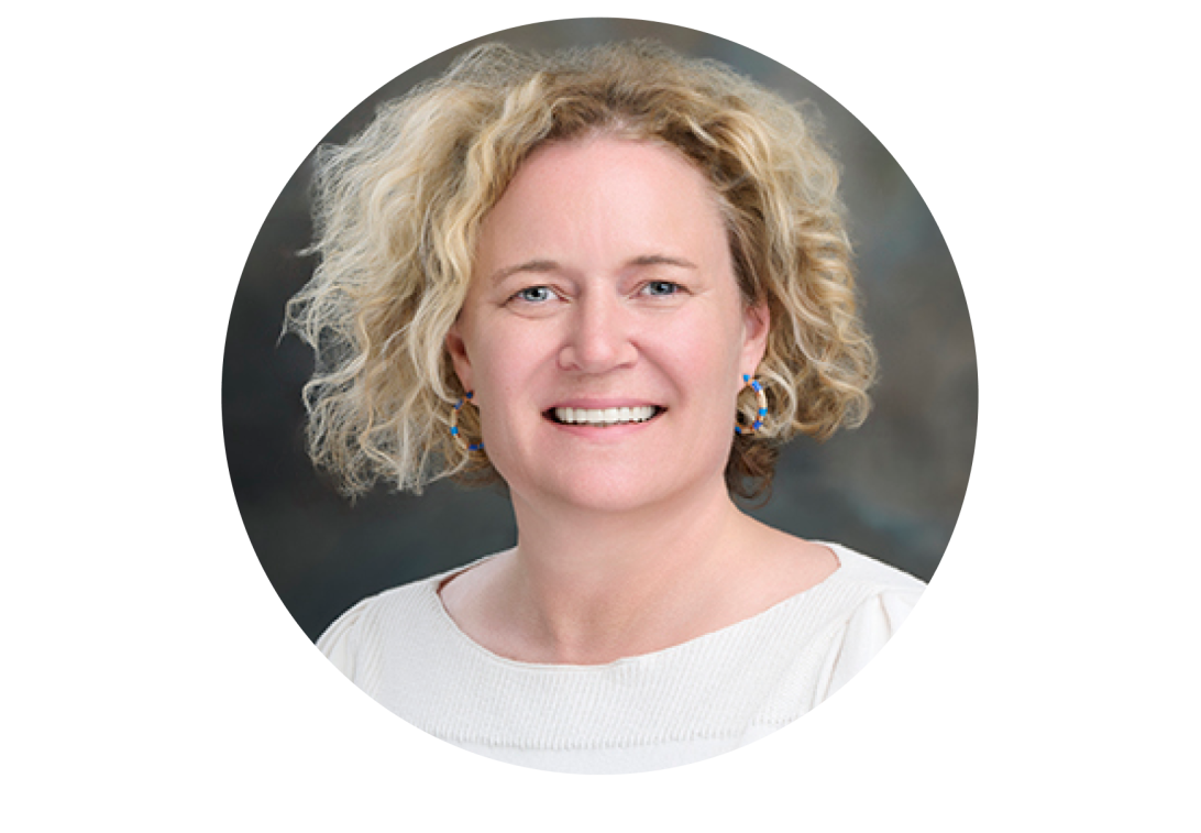 A portrait of Hedi Holtz smiling with a white blouse.