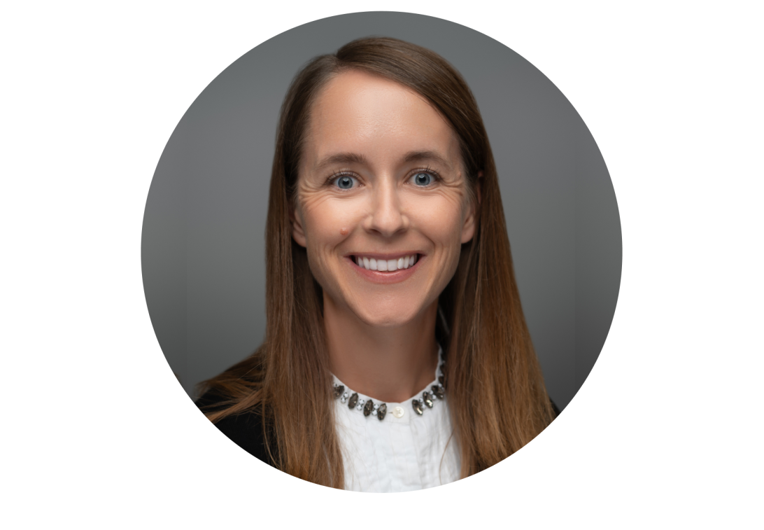 A portrait of Joann Jabbari smiling with a black dress coat and white blouse.