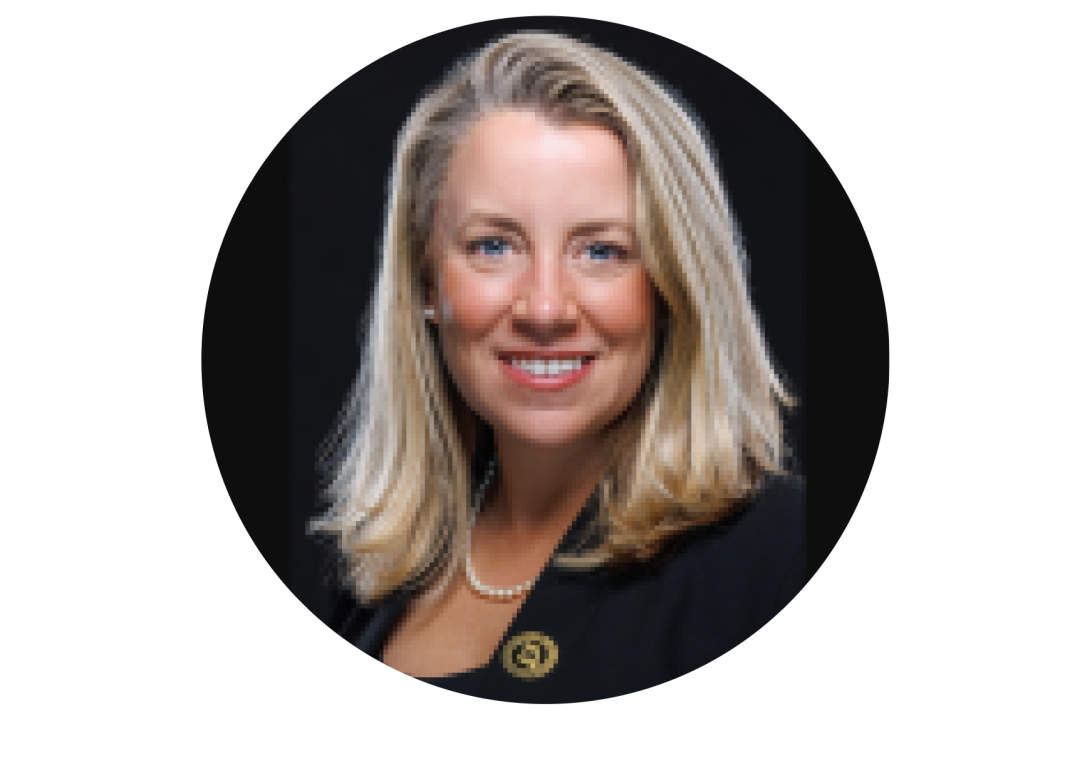 A portrait of Sarah Oerther smiling with a black dress coat.