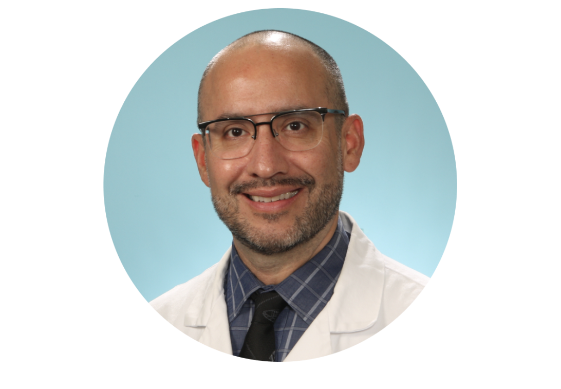 A portrait of Dr. Brian Torres smiling with a white doctor coat.
